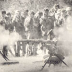 WO2 Charlie Krause, crouched in foreground operating the weapon.